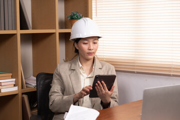 Asian project manager or architect female using digital technology tablet assigning work checking...