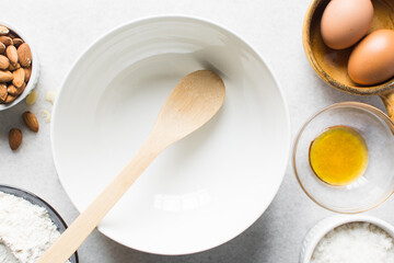 overhead view of ceramic bowl with a wooden spatula on a marble table, white ceramic mixing bowl