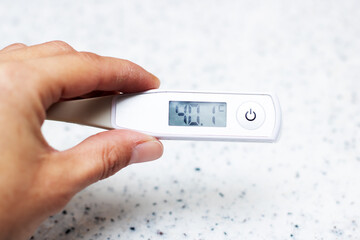 Temperature of 40.1 shown on digital thermometer held by hand