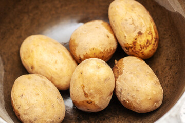 Potatoes, a staple food, are being boiled in a pan with water