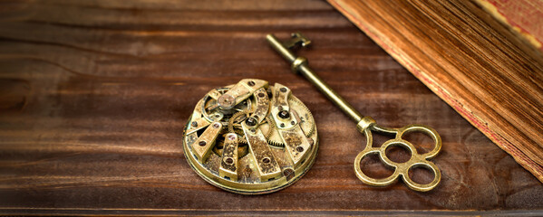 Key and clockwork on a wooden background, escape room game banner