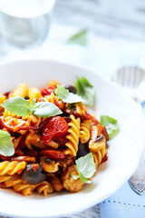 Pasta with cherry tomatoes, and olives. Bright wooden background. Close up.
