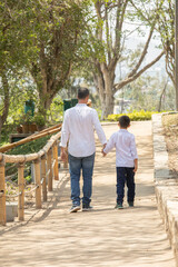 Family members walking together holding hands in a sunny day in a park in Lima Peru