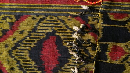 Handmade woven textile with unique pattern from Indonesia,  close up textured multicolor fabric background, traditional clothing in southeast asia