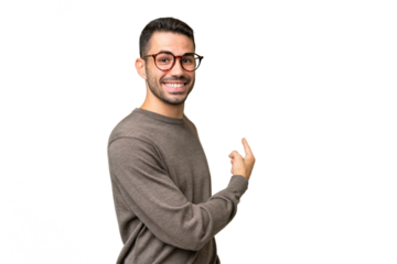 Young handsome caucasian man over isolated background pointing back