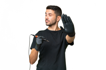 Tattoo artist caucasian man over isolated background making stop gesture and disappointed