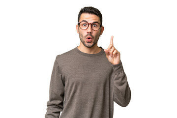 Young handsome caucasian man over isolated background intending to realizes the solution while...