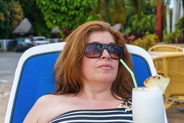 Tourist woman drinking a Pina Colada cocktail, Cuba