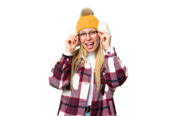 Young pretty blonde woman wearing winter muffs over isolated chroma key background with glasses and...