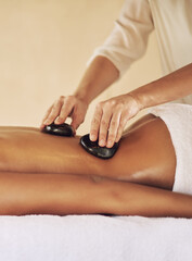 Woman, relax and hands with rocks at spa for lomi lomi massage, treatment or skincare and wellness....