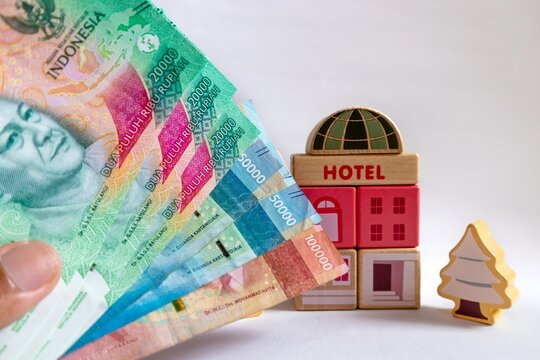 Indonesian rupiah banknotes with a hotel wooden toy in the background. Holiday concept.