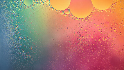 Abstract yellow, green and pink colorful background with oil on water surface. Oil drops in water...