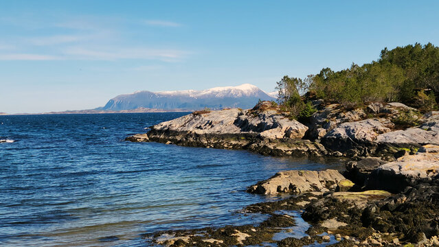 Coastal view of snow capped mountains.