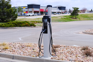 Electric vehicle charging station in a parking lot city street view photo. EV charger for electric...