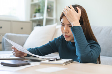 Stressed asian young employee, business woman calculate tax, income and expenses, hand looking...