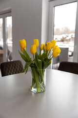 yellow tulips in a vase on the table