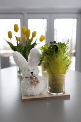 yellow tulips in a vase on the table with an easter bunny decoration