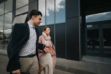 Two business professionals, a man and a woman, engaging in a conversation while walking in a business district. - obrazy, fototapety, plakaty