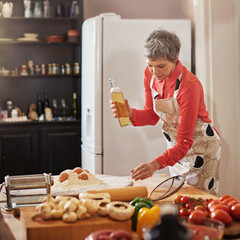 Food, cooking and senior woman in kitchen with olive oil, egg or flour for meal prep, fun or hobby...