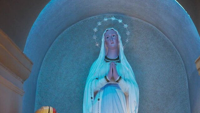 Statue of the Madonna. Mary prays, passion of Jesus. Sacred objects in church. Catholic religion.