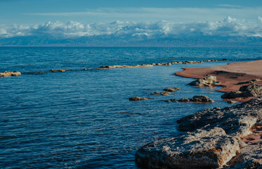 Rocky lake shore of Issyk-kul lake in Kyrgyzstan in spring