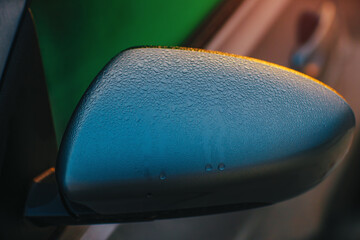 Close-up of car mirror with water condensation in the morning