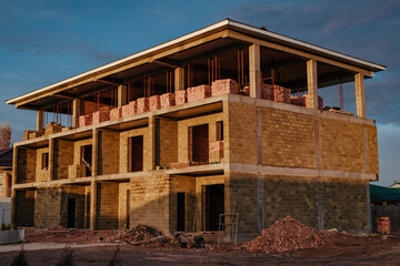 Construction of three-storey building at sunrise light