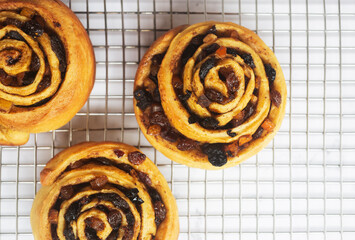 Freshly baked mixed fruit cinnamon rolls on a cooling rack