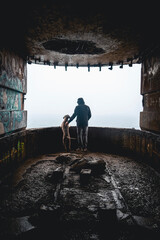 Man with a Weimaraner dog in a bunker on the coast of Brittany, France. Man shows the landscape to...