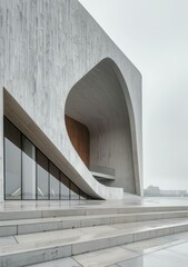 b'A modern building with a curved entrance and a large glass window'