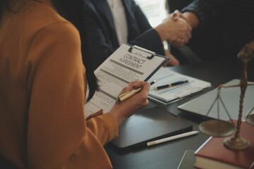 Justice and Law concept. Legal counsel presents to the client a signed contract with gavel and...