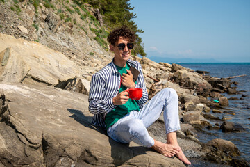 A young attractive guy is resting by the sea.