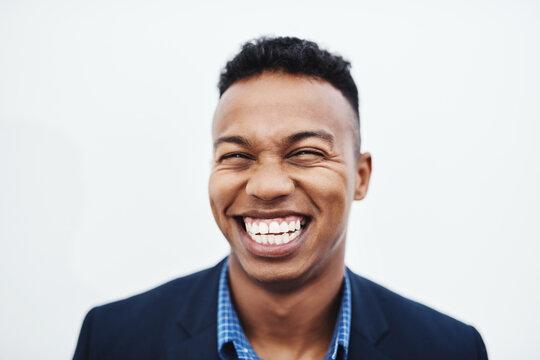 Happy, face and businessman laughing in studio with funny, teeth and feel good mood, confidence or personality on white background. Comic, silly and African model smile for goofy joke or comedy
