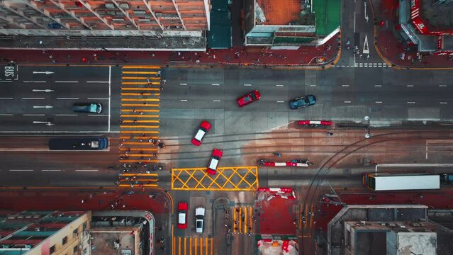 Aerial top down view of Hong Kong street intersection, highlighting the dense urban traffic and contrasting building exteriors