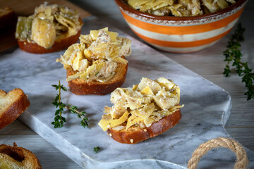 Bruschetta with artichoke salad, Parmesan cheese, truffle salsa and thyme leaves.