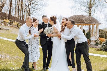 A group of people are posing for a picture, including a bride and groom