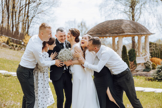 A group of people are gathered together, including a bride and groom