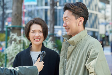 Obraz premium 街頭インタビューを受ける男女