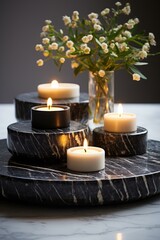 b'Black marble table with white candles and a vase of flowers'