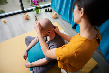 Masseuse making thai yoga massage. Woman therapist doing traditional massage treatment for male...