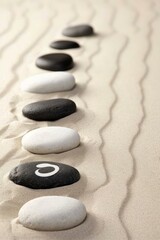 Fototapeta na wymiar b'Pebbles in the sand with a symbol'