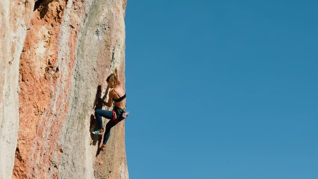 rock climbing and mountaineering. rock climber girl. A girl overcomes a difficult climbing route. Extreme hobby. A woman plays sports in nature. path to the goal.