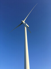 detail of sustainable energy wind turbine, with light blue background, vertical image