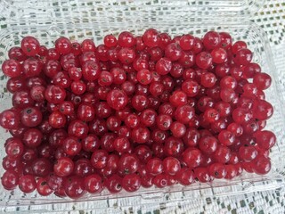 A close-up of farm fresh red currants in a container on a table at a farmer's market