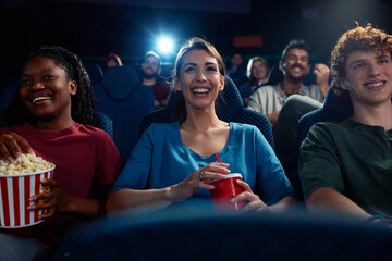 Happy woman enjoying movie screening with friends in cinema.