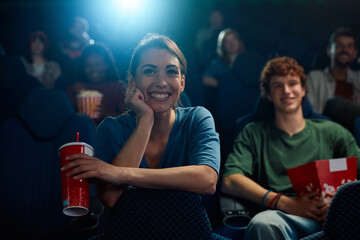 Young happy woman watching movie in cinema.
