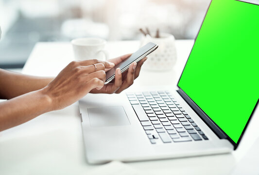 Cellphone, laptop and green screen in person office, desk and typing for business communication. Technology, mock space and corporate for web design agency, computer and internet planning or online