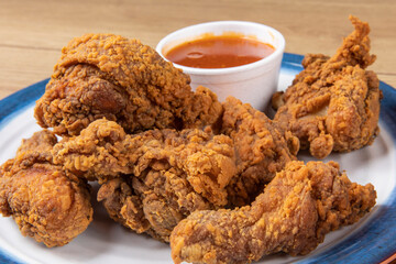 crispy southern style fried chicken pieces on a plate with dipping sauce
