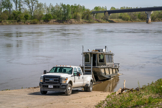 Waverly, MO, USA - April 22, 2024: Launching a working boat by Munson on a boat ramp on the Missouri River.