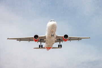 Obraz premium Toronto, Canada, April 4, 2022; Head on overhead view of an Air Canada Rouge economy and vacation brand Airbus A320 jet airliner approaching Pearson Airport YYZ for landing